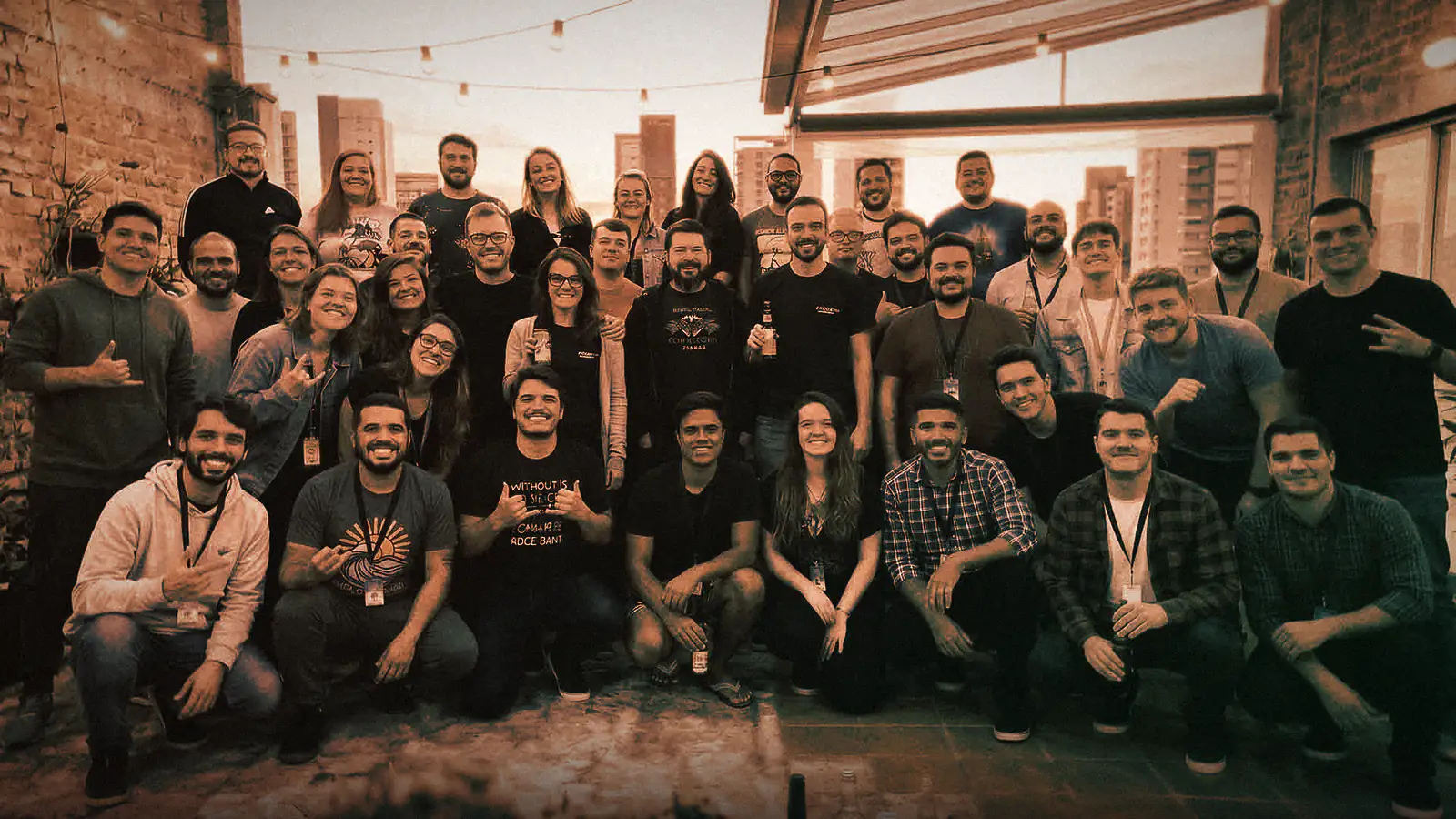 The YourSite24h team gathered on a rooftop at sunset, with the city in the background